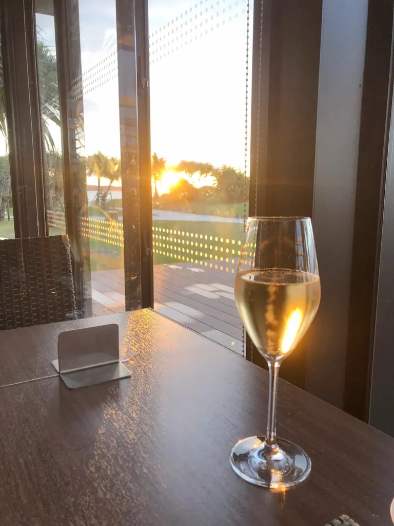 窓際のシャンパングラスと夕日の写真